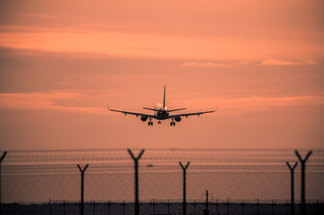 Wall Mural - Airplane landing at sunset