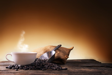 Wall Mural - Cup of coffee  and coffee beans on old wooden background