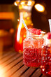 Fresh homemade lemonade with raspberries in mason jar glasses on wooden table