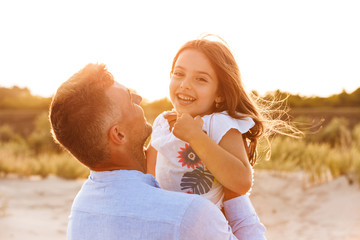 Cute family having fun together outdoors at the beach.