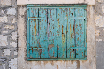 Old wooden window shutters painted in turquoise