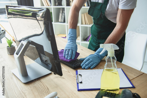 Fotografía cropped shot of professional cleaner in rubber gloves cleaning computer keyboard