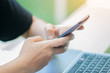 © smolaw11 - Online searching social networks by Smartphone Concept: Hand of Woman pointing finger on blank screen smart phone, using hand clean gadget or typing sms message to her friends in coffeeshop background