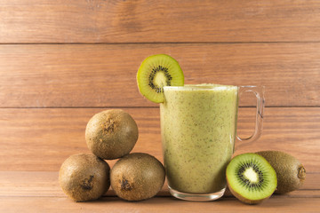 Wall Mural - Kiwi smoothie on wooden background.