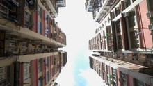 Low Angle View Of Crowded Residential Towers In An Old Community In Hong Kong. Scenery Of Overcrowded Narrow Apartments, A Phenomenon Of High Housing Density. Rotating Camera