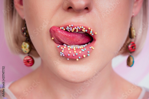 Portrait Of Beautiful Blonde Barbie Woman Perfect Makeup Tongue Sexy Licking Lip Donuts Earrings Background In Portrait Of Beautiful Blonde Barbie Woman Perfect Makeup Tongue Sexy Licking Lip Donuts Earrings Background In