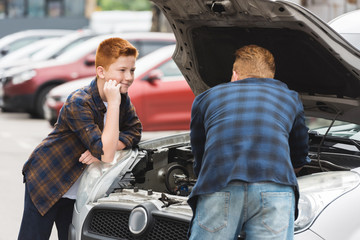 Wall Mural - son looking how father repairing car with open hood