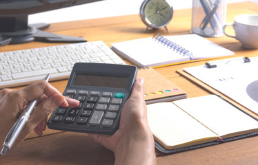 Person working and using a calculator for financial and accounting concept.