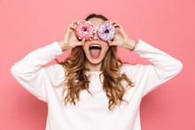Portrait Of A Happy Young Woman Showing Donuts