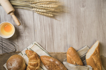 fresh bread and wheat on sack and wooden table.