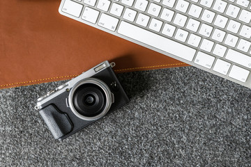 Wall Mural - Office environment with computer keyboard and camera on desk as flat lay from above