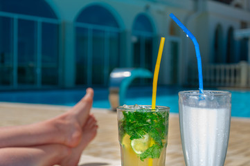 Two Colorful Tropical Cocktails near the Swimming Pool. Mojito and milk coctails. Exotic Summer Vacation.