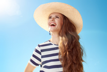 Sticker - happy modern woman looking into distance against blue sky