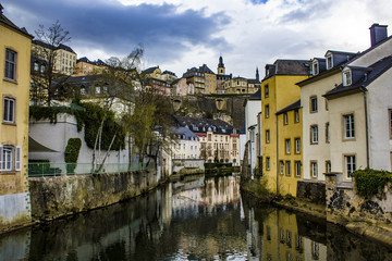 Wall Mural - Traditional European Buildings in the Village of Grund Reflecting on the Water of the Alzette River in Luxembourg City, Luxembourg