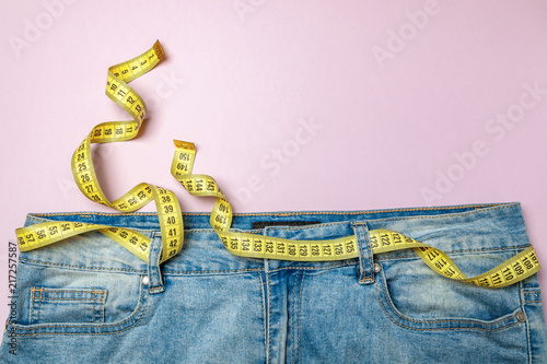 Cuadros en Lienzo Jeans and yellow measuring tape instead of belt on pink background