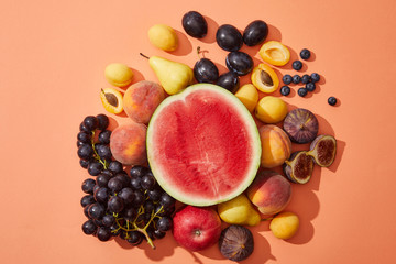 Wall Mural - top view of various fresh ripe sweet fruits on red