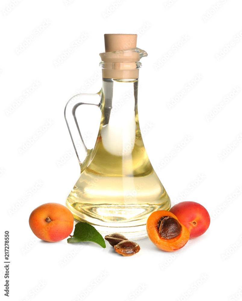 Glass jug with essential oil and fresh apricots on white background