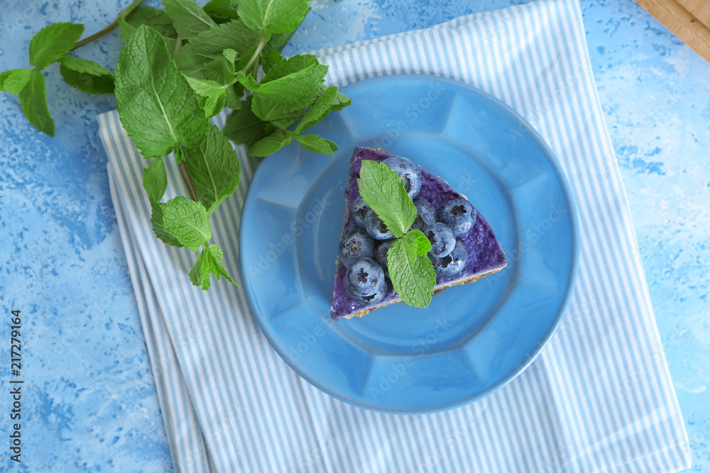 Plate with delicious blueberry cheesecake on table