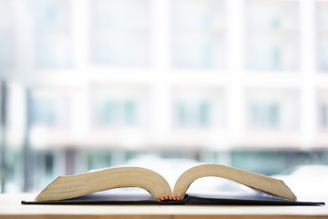 Knowledge concept, A book open on wood table with copy space.