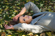 © dobok - one young fashion woman lie on the ground in a park in autumn
