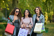 © dobok - three young woman with shopping bags in a park in autumn