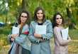 © dobok - three student woman with textbook in a park in autumn