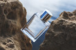 Perfume bottle located on the rocks in the sunlight