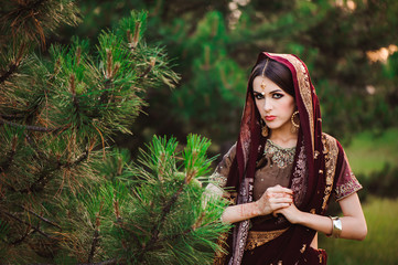 Wall Mural - Beautiful young caucasian woman in traditional indian clothing sari with bridal makeup and jewelry and henna tattoo on hands