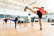 Instructor And Clients Kickboxing In Dance Class At Gym