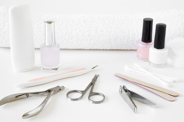 Set of nails tools and towel on the white table. Care about women's and men's hands or feet nails. Manicure and pedicure beauty salon.