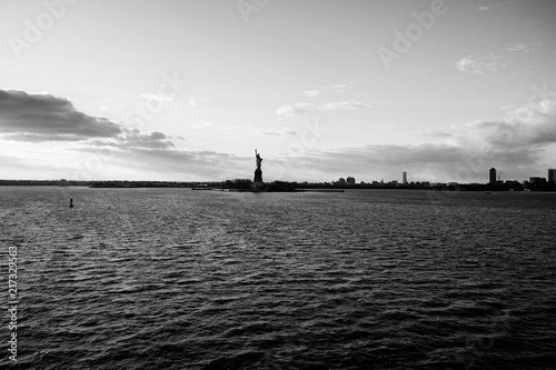 Fotografía  Hudson river view with the silhouette of the statue of Liberty against the blue sky and infinite horizon at sunset