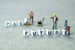 words past blurred and future sharp on grey background with miniature figurines