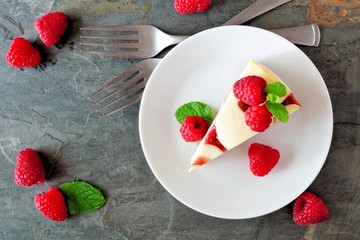 Poster - Slice of raspberry cheesecake on a plate, top view scene over a dark background