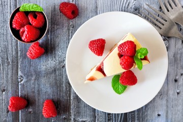 Poster - Slice of raspberry cheesecake on a plate, top view scene over a rustic gray wood background