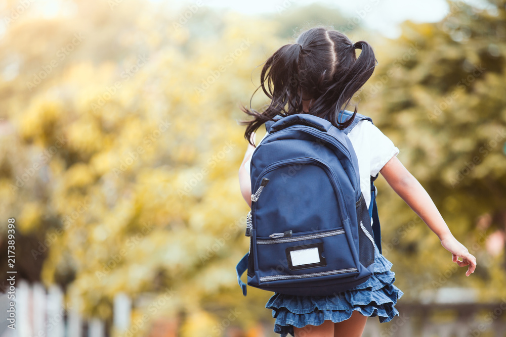 Back to school. Cute asian child girl with backpack running and going to school with fun - obrazy, fototapety, plakaty 