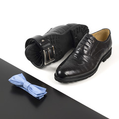 The black man's shoes and accessories isolated on white and black background.