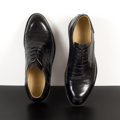 Pair of black male classic shoes on white background