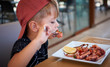© Polymesh - Little boy eating tasty octopus