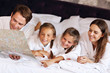 © Kalim - Happy family relaxing in hotel room