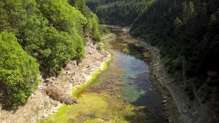 Wall Mural - aerial drone view climbing away from a long lake located inside a steep, narrow canyon surrounded by
