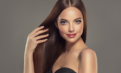 Beautiful brunette girl with long straight smooth hair . A woman with healthy straight hairstyle 
