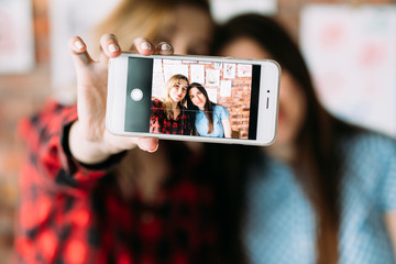 Wall Mural - art blogging and mobile photography. painting courses or classes students taking a selfie on mobile phone in workshop.