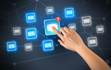 Female hand touching unread mail icon with more envelope icons around it 