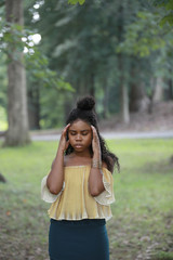 Wall Mural - Thoughtful ethnic woman standing in woods with eyes closed