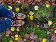 Looking down at woman's feet in hiking boots on a rainy colorful autumn day