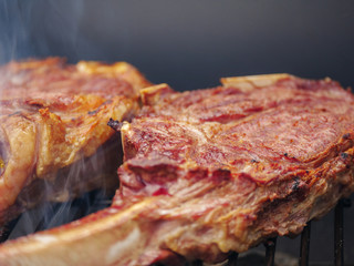 Two tomahawk steaks on the grill. BBQ time. close up