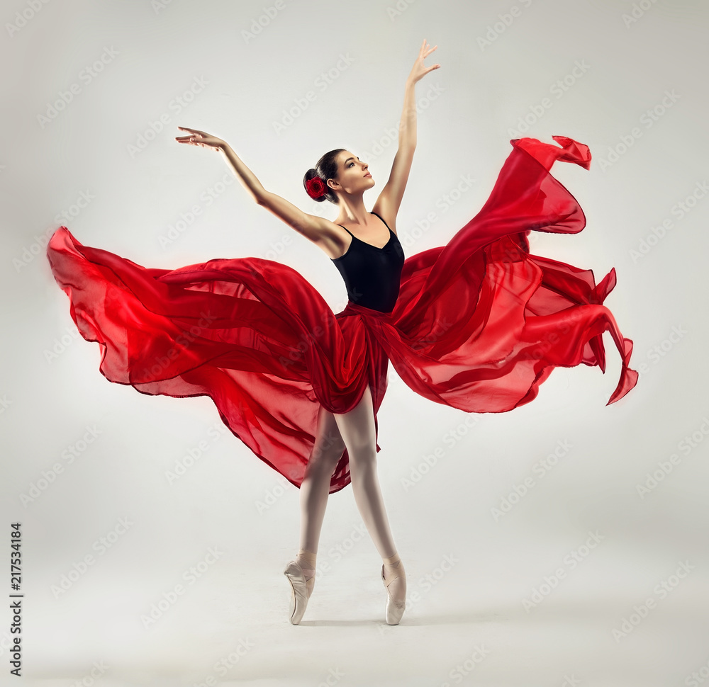 Ballerina. Young graceful woman ballet dancer, dressed in professional outfit, shoes and red weightless skirt is demonstrating dancing skill. 
Beauty of classic ballet dance. 
 - obrazy, fototapety, plakaty 