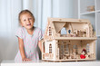 © Evgenia Tiplyashina - a girl playing with a dollhouse