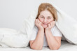 © Ermolaev Alexandr - Happy senior woman lying uder blanket