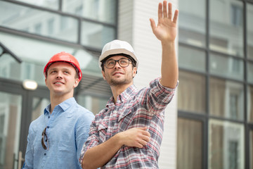 Wall Mural - prosperous master builders waving hands. greeting concept. low angle view